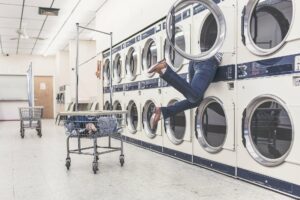 Woman falling in machine at laundromat.