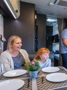 A young man preparing a cup of tea for his family in a modern Australian Caravan