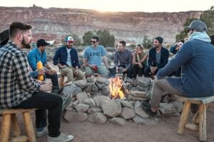 Group of campers sitting around fire.