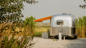 Airstream RV with orange awning extended. 