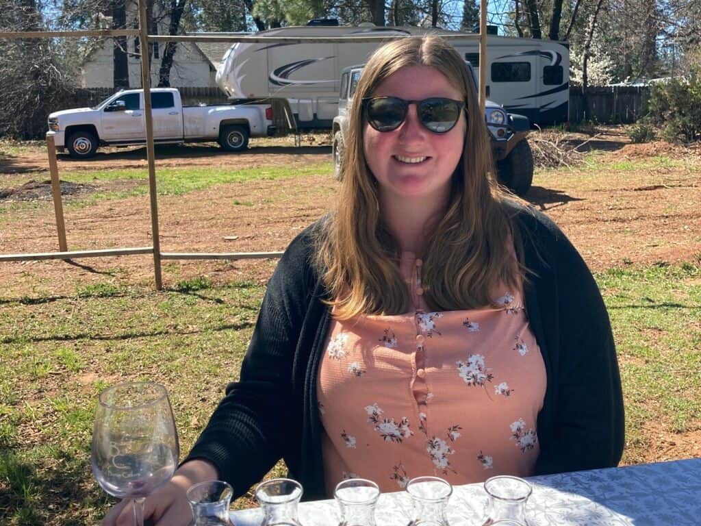 Woman drinking a wine flight at a Harvest Hosts location with RV camping