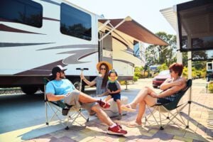 Family sitting at RV campsite.