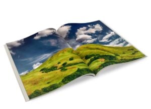 Magazine open to photo spread of green hills