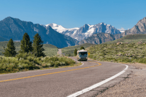 Class A Diesel Pusher driving with mountains in the background