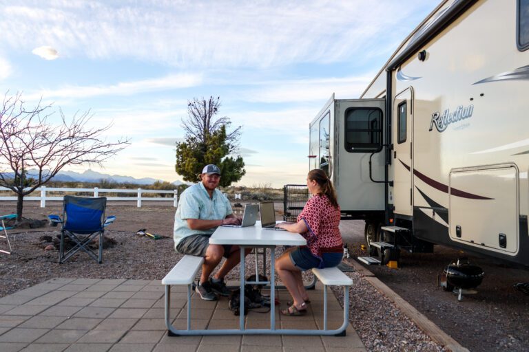 Couple working jobs from laptop at RV