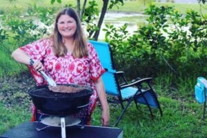 Woman cooking on grill. 