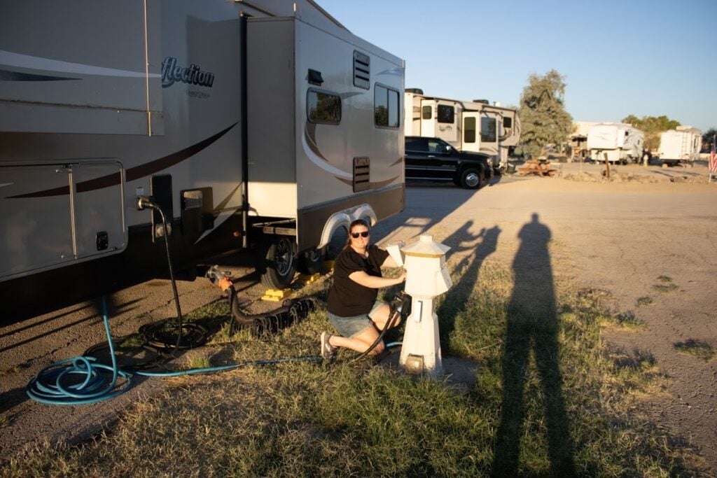 Woman plugging in RV shore power.