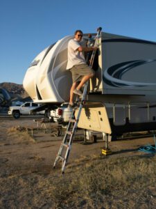 RV tech on ladder
