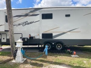 Side of RV with utilities including power and a water filter. 