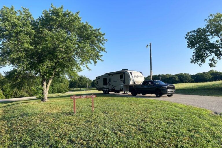 RV driving out of campground in green, Spring scenery.