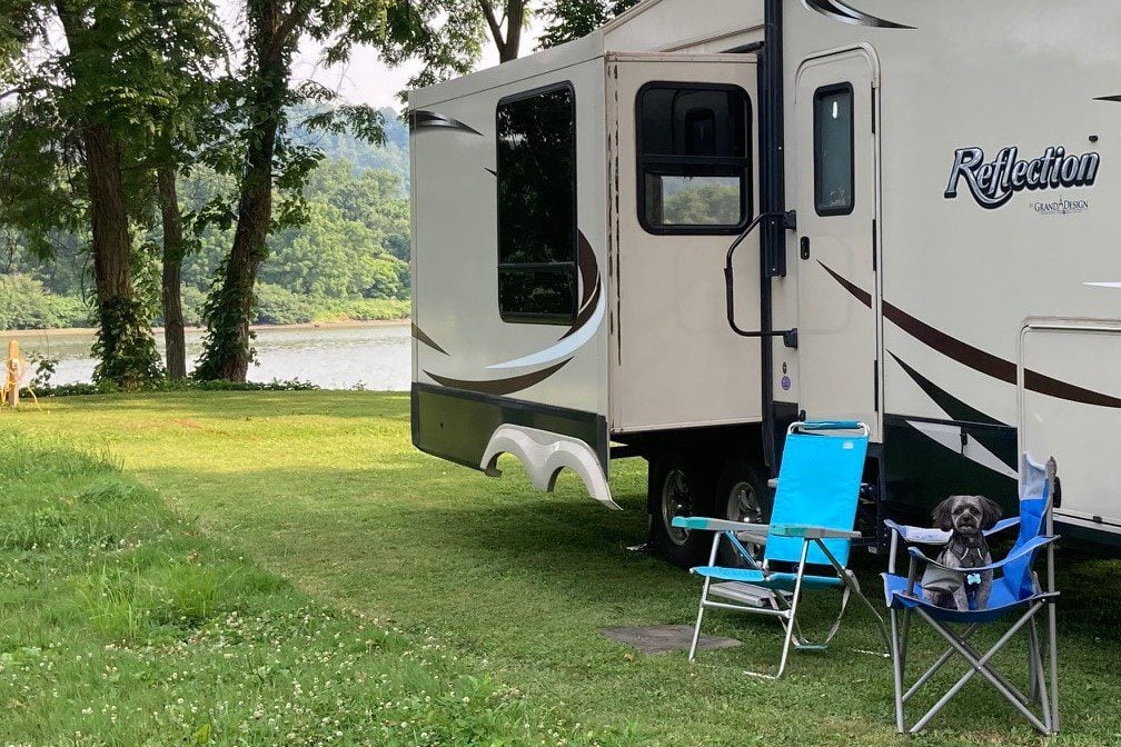 Dog sitting in chair in front of fifth wheel RV