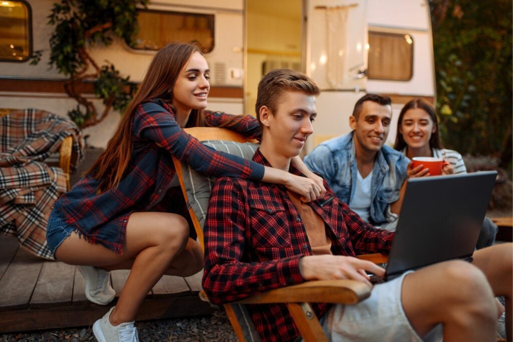 Friends on laptop at RV campsite.