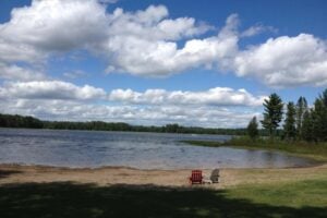 Luxury RV Resorts in Michigan. Chairs on lake beach at Silver Lake Resort.