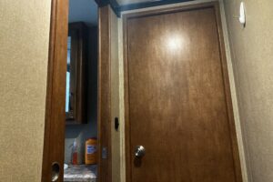 Hallway with one open and one closed door in RV camper.