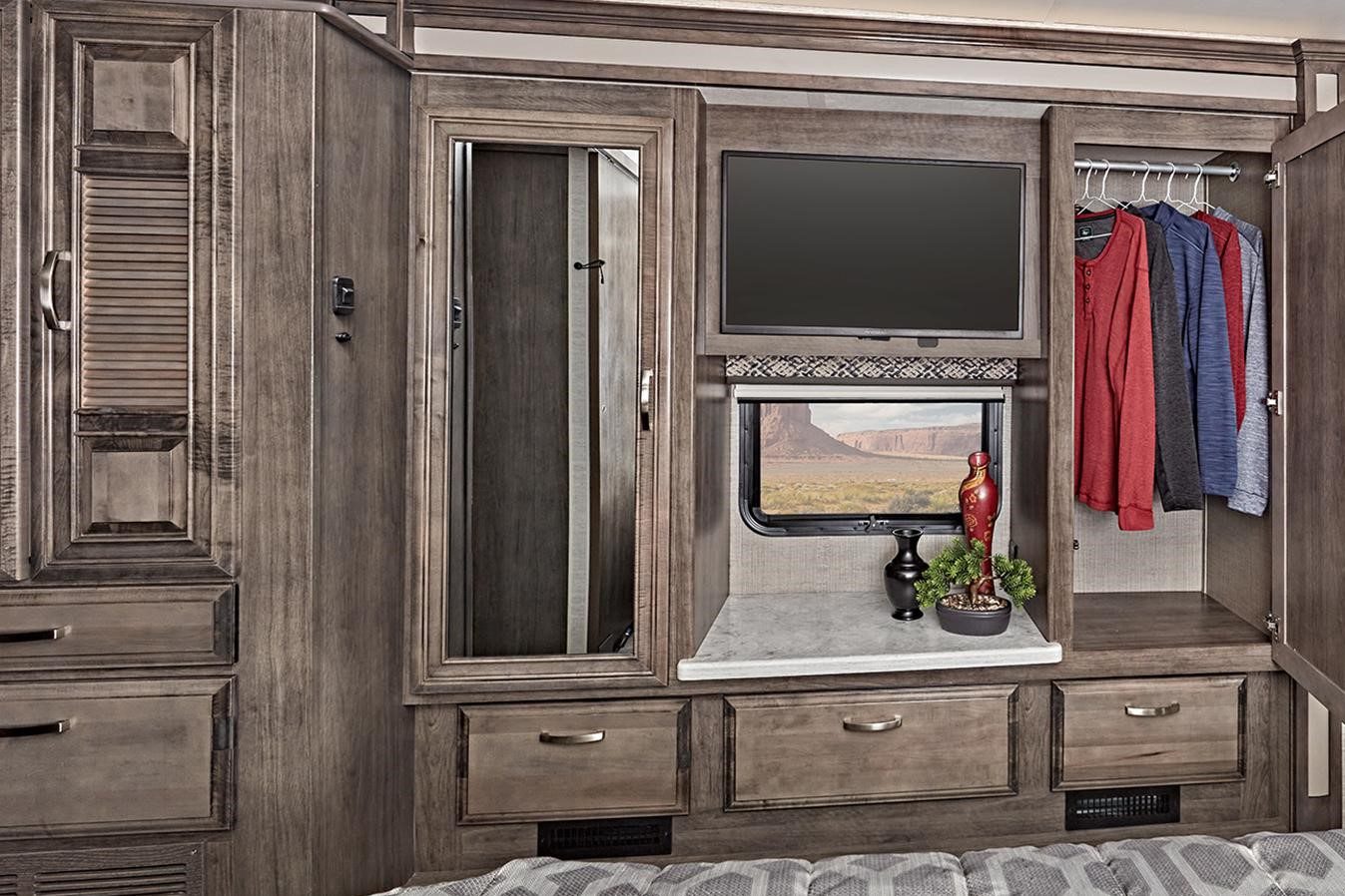 Wardrobe cabinets around window in bedroom on an RV.