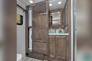 RVs with a washer and dryer in bathroom cabinet.