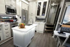 Kitchen and dining area with white cabinets inside an RV.