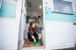 Woman sweeping dirt from RV