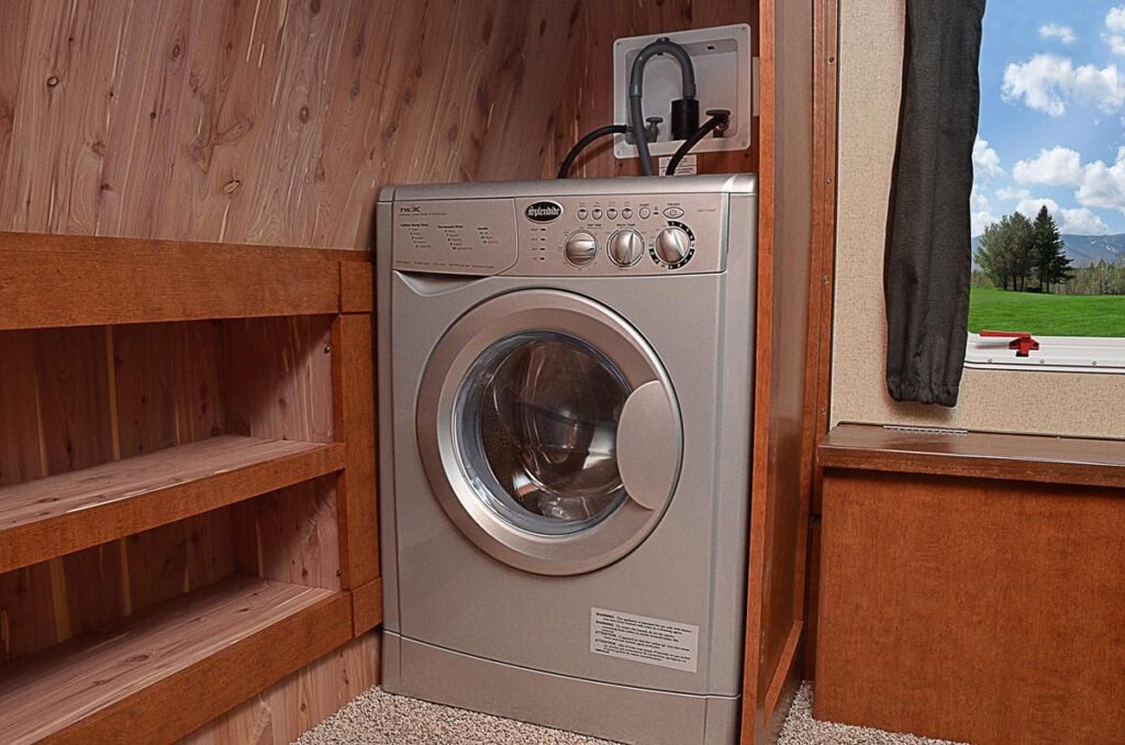 Gray combination washer and dryer in an RV closet with view of window.