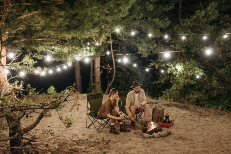 couple by campfire sitting in heated camp chairs