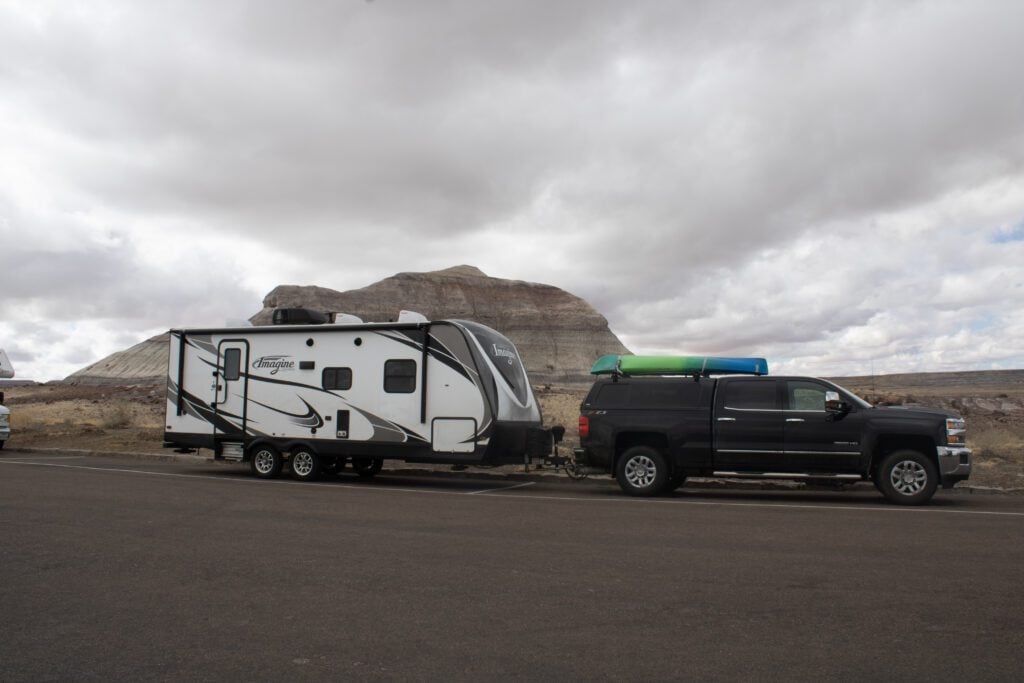 Truck with kayak on top, hitched to travel trailer