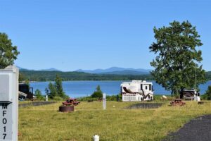 Waterfront RV park with mountains in background.