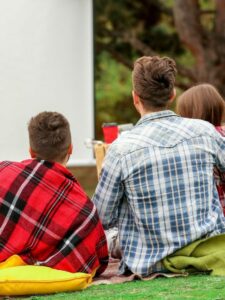 Friends watching movie while camping