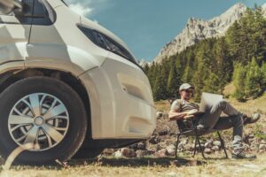 Man on road trip working at campsite