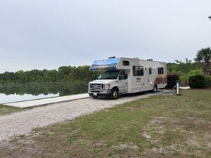 Cruise America Wrapped Rental RV at Lakefront Campsite.