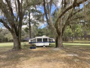 Pop up camper parked under trees