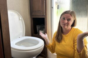 Woman beside clogged RV toilet