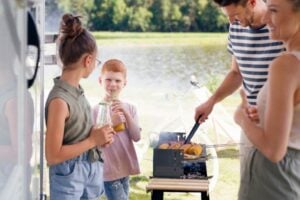 Family grilling at RV campsite.