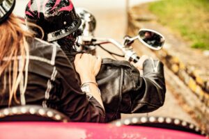 Coupe riding on motorcycle towing small camper