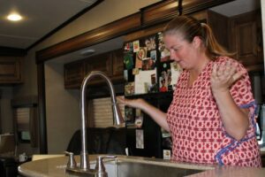 Woman standing above RV sink with no hot water
