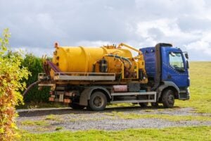 RV honey wagon with yellow tank and blue cab.