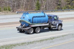 RV honey wagon driving down road/