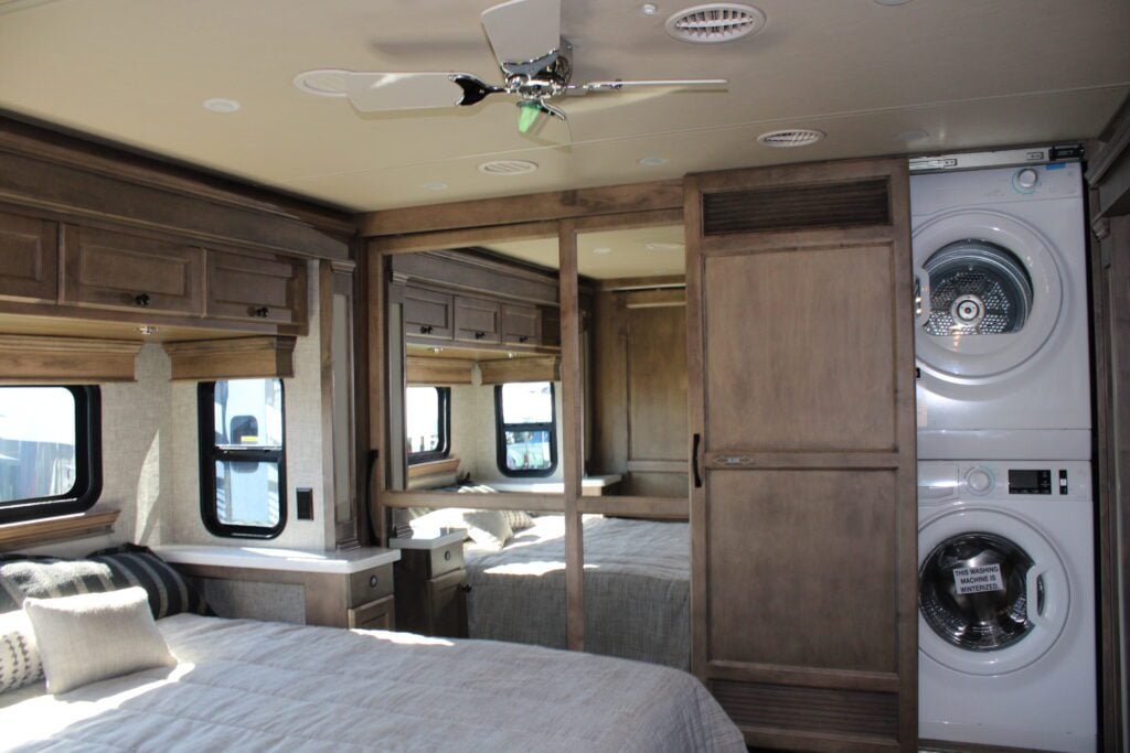 RV bedroom with stacked washer and dryer.