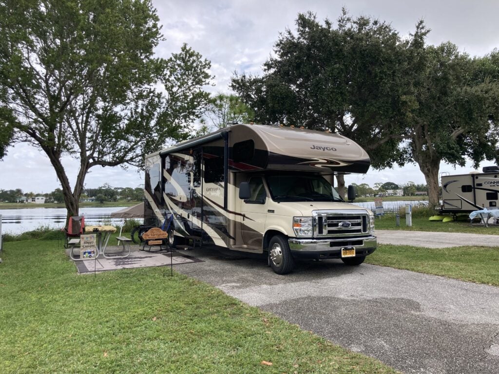 Class C RV at decorated lakefront campsite.