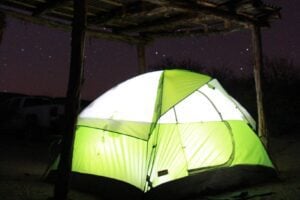 Tent lit up under night sky.