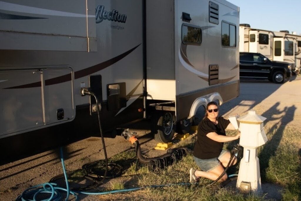 Woman plugging in RV power with surge protector.