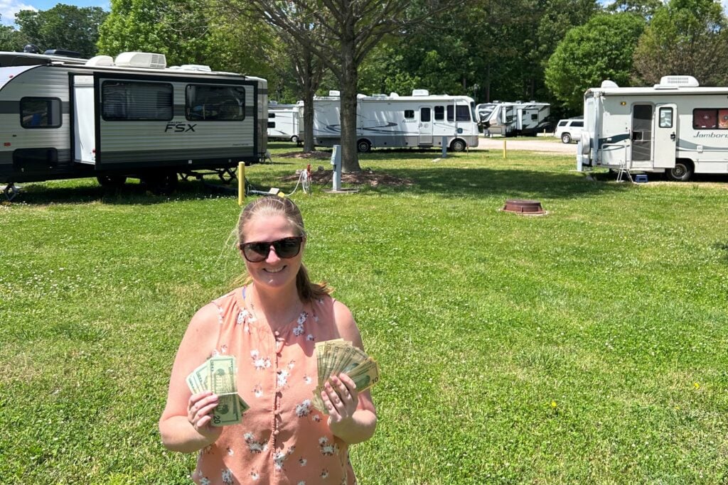 Woman holding money in front of RV