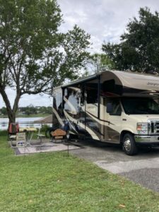 Class C RV at decorated lakefront campsite.
