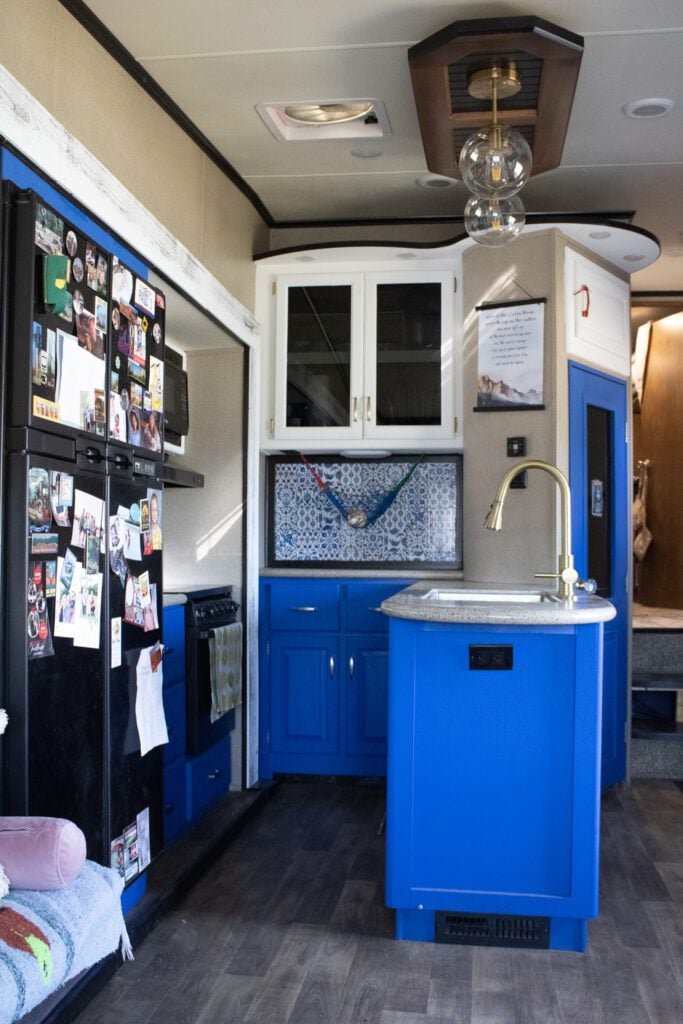 Remodeled RV kitchen with bright blue lower cabinets.