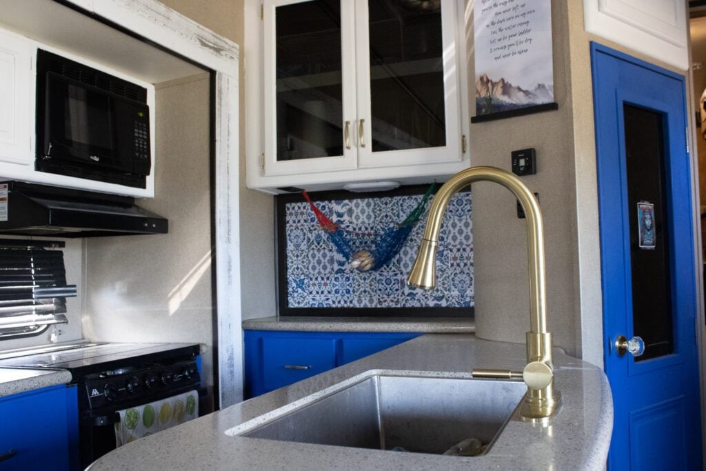 Remodel RV kitchen with gold faucet and blue cabinets.