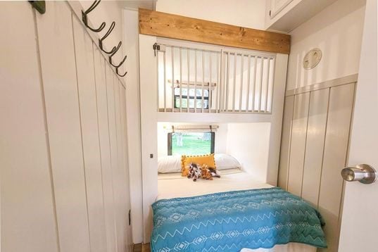 RV bunk room with upper bunk converted into custom crib.