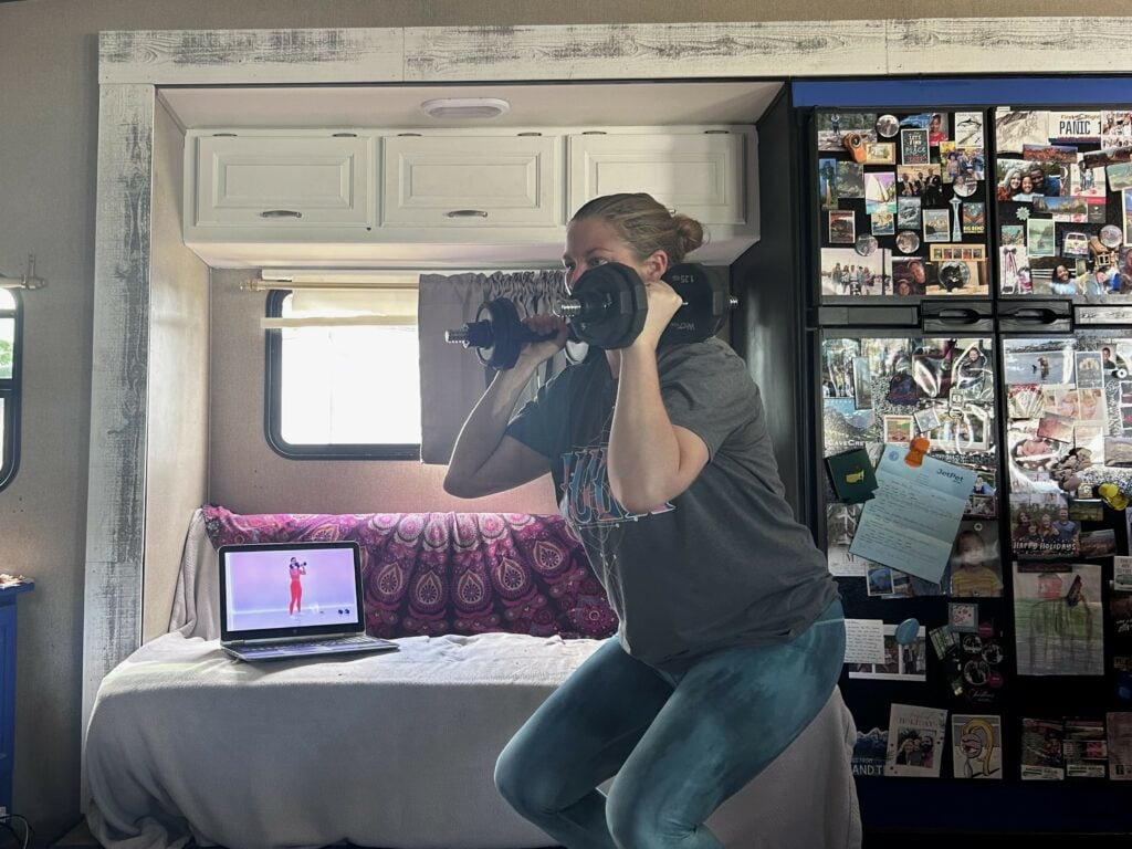 Woman taking online workout class inside RV.