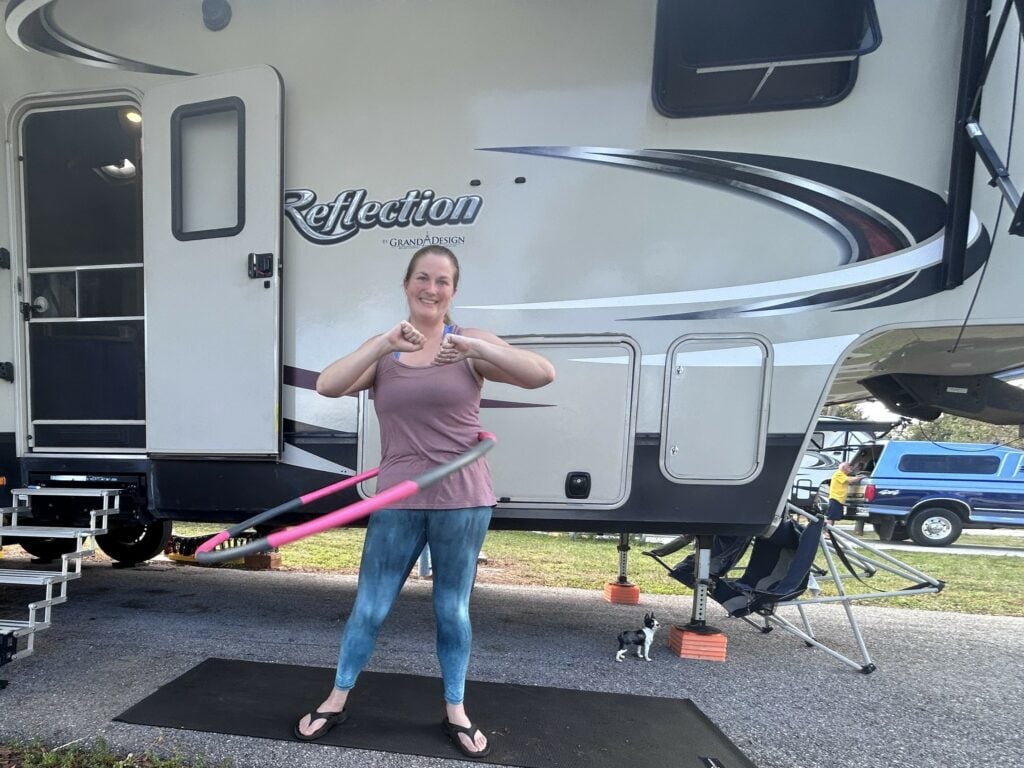 Woman doing hula hooping workout outside RV.