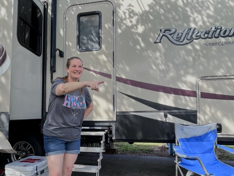 Woman pointing and laughing outside RV.