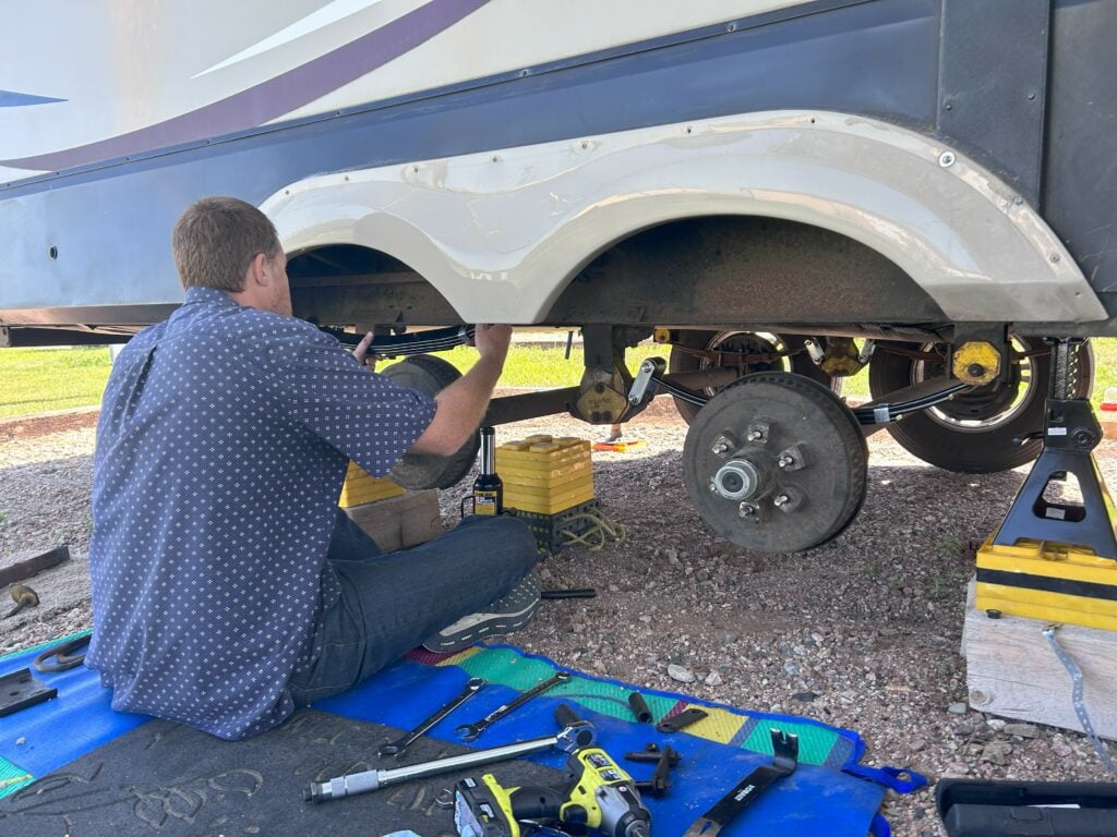 Man replacing RV leaf spring