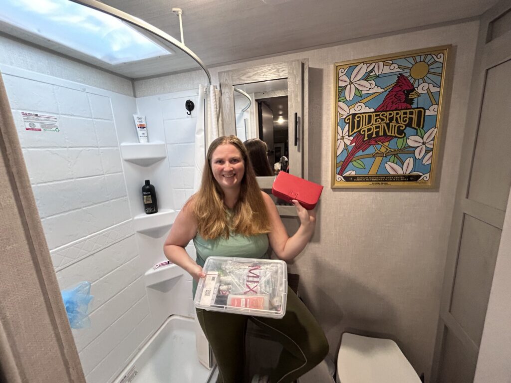 Woman holding storage containers in RV bathroom